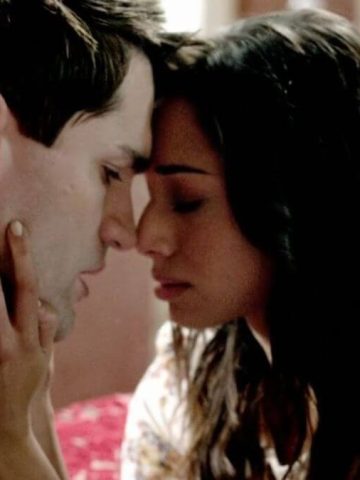 Aidan and Sally Being Human romantic moment featured image. The picture shows Aidan and Sally about to kiss while sitting on a couch.