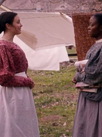 Emma and Jane talk outside while doing laundry.