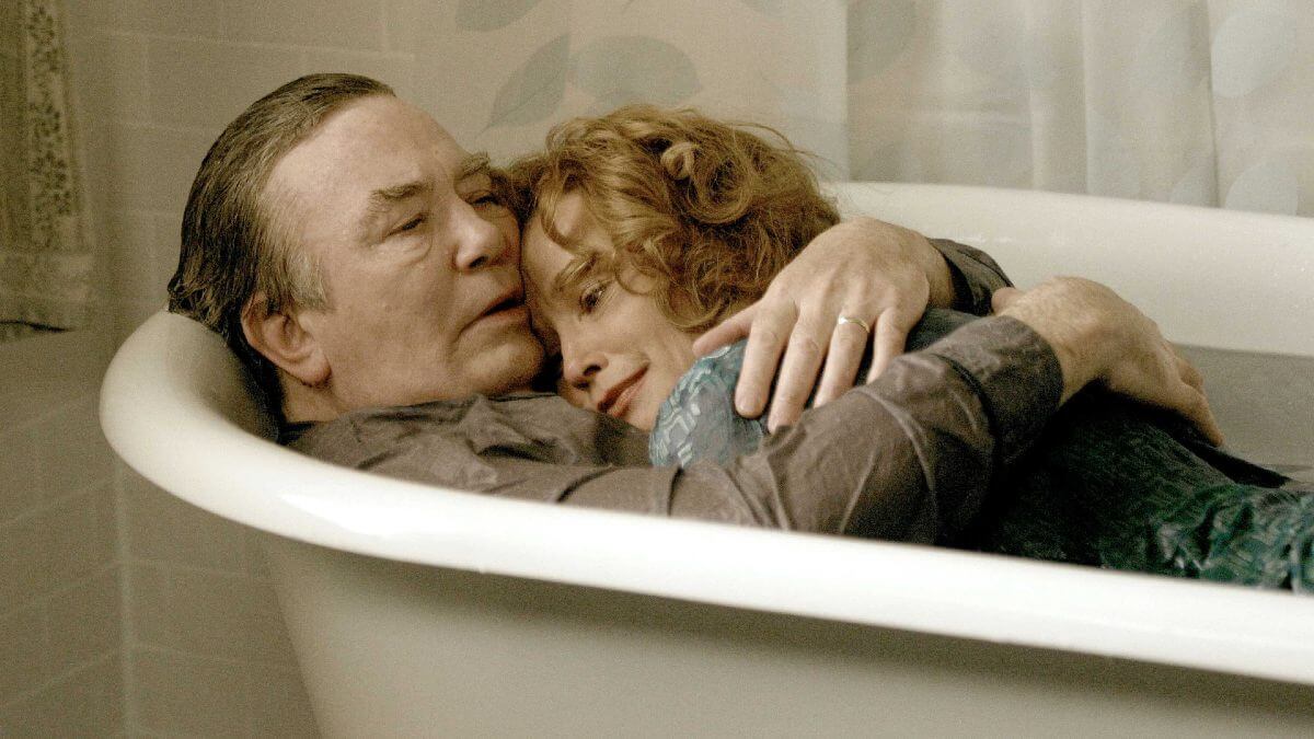 Big Fish photo of an older couple hugging while still wearing clothes in a bathtub