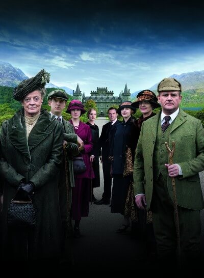 The Downton Abbey cast with Highclere castle in the background