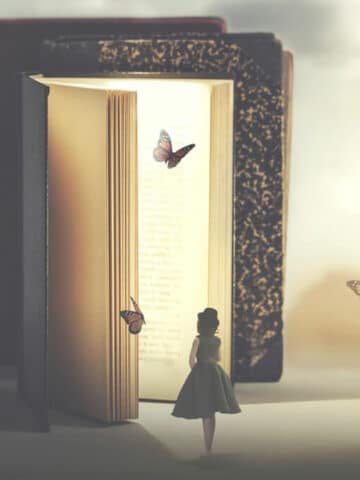 what is creativity and how to be creative featured image. The picture shows a woman standing in front of a lifesize book with butterflies.