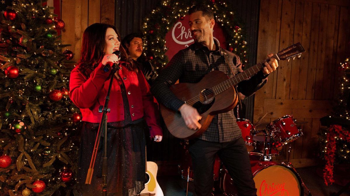 A country christmas harmony movie; the image shows a couple singing with holiday decorations in the background.