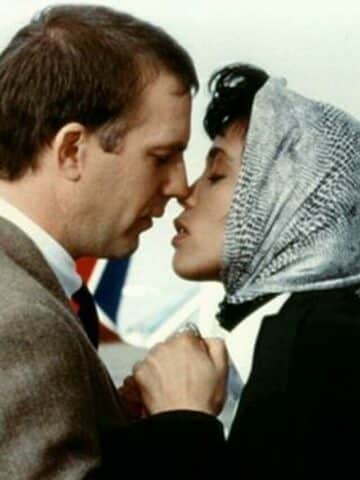 the bodyguard review featured image with Kevin Costner and Whitney Houston about to kiss.