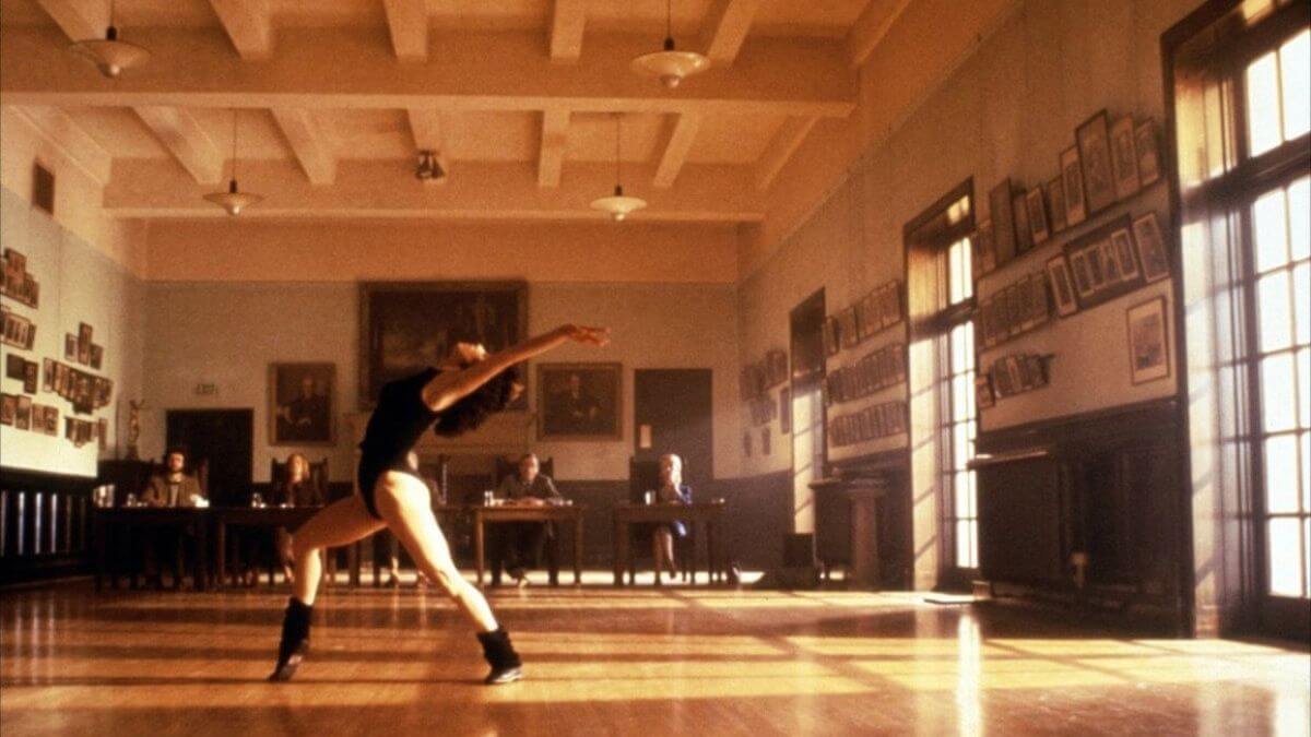 Flashdance 1983 publicity still of a young woman dancing in front of a panel.